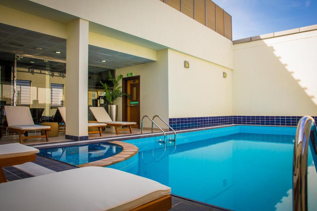 阿布扎比Grand Villaggio Hotel Abu Dhabi的大楼内的一个蓝色海水游泳池