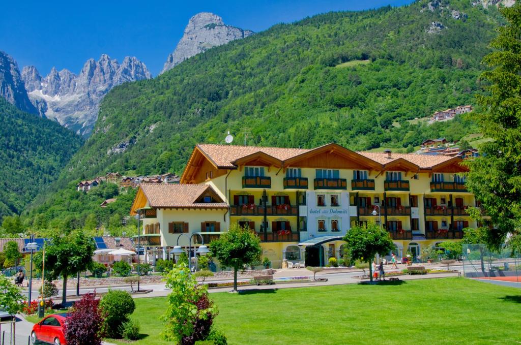 莫尔韦诺Alledolomiti Boutique Lake Hotel - Adults friendly的一座大酒店,背景是一座山