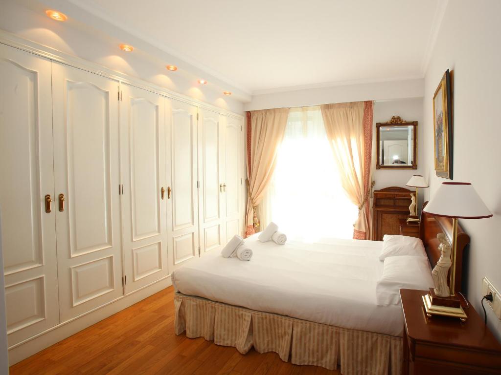 圣塞瓦斯蒂安Apartamento Ondarreta的卧室设有一张白色大床和一扇窗户。