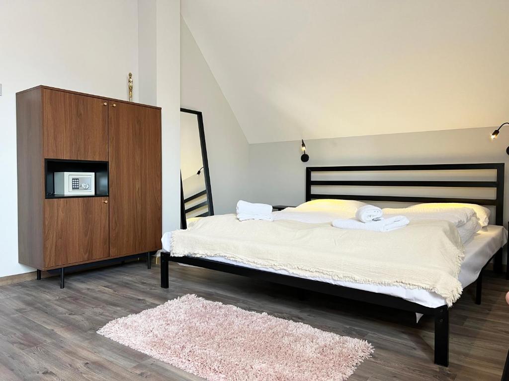 凯斯特海伊Nussbaum Panzió的一间卧室配有一张大床和一个木制橱柜