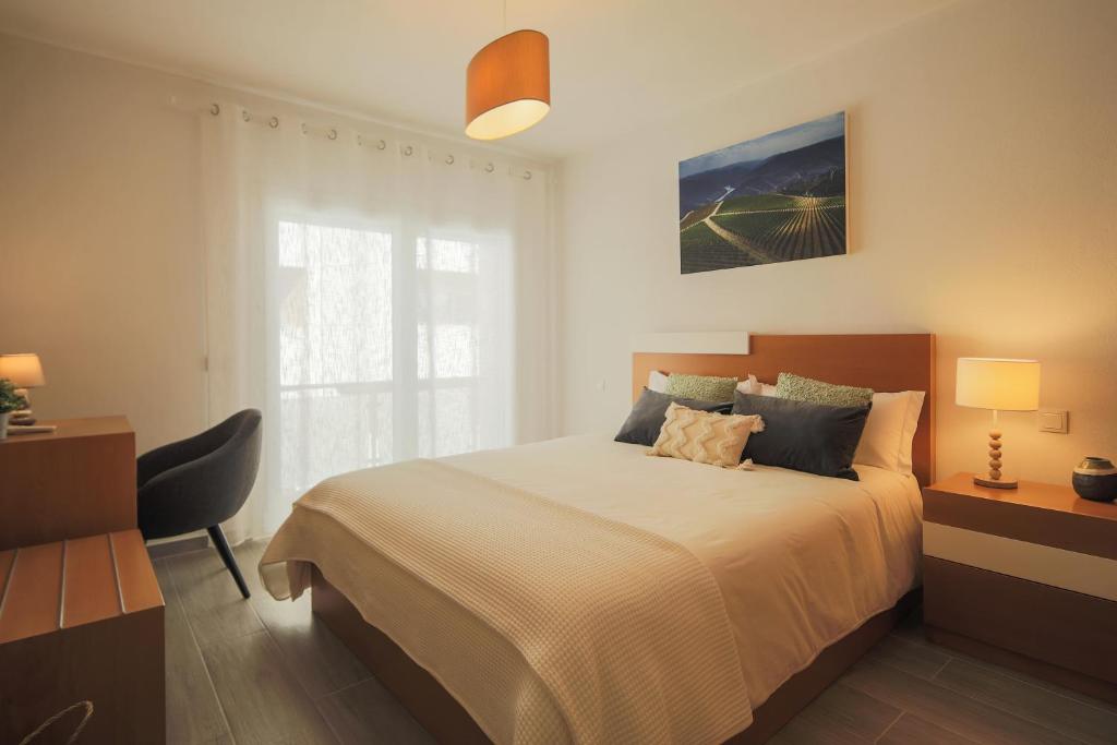比索达雷加Casa dos 4 Caminhos - Guest House Douro的一间卧室设有一张大床和一个窗户。