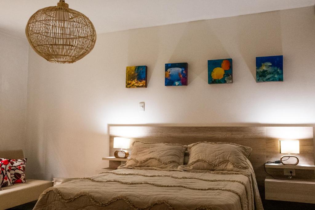 麦德林Hotel Casa Esencia的卧室配有一张壁挂着四幅画作的床