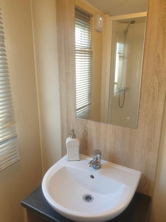 KentGriffiths, Seaview Caravan Park, Whitstable的浴室设有白色水槽和镜子
