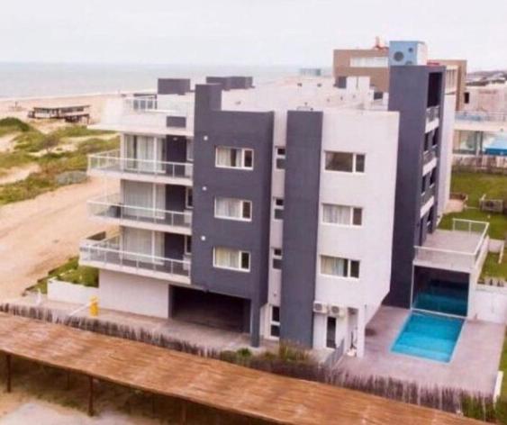 格塞尔镇Departamento Apart Espacio Marina的一座大型白色建筑,设有海滩旁的游泳池