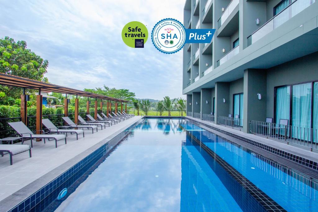 奈扬海滩Sugar Marina Hotel -AVIATOR- Phuket Airport - SHA Extra Plus的酒店一侧的游泳池
