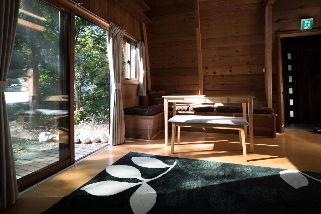 白马村Yukiita Lodge的客厅设有桌子和大窗户