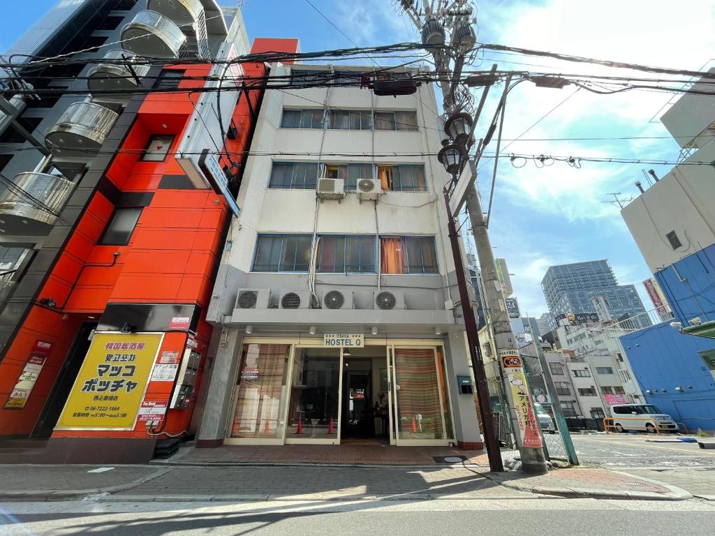 大阪Q旅馆的城市街道上一座拥有橙色外墙的建筑
