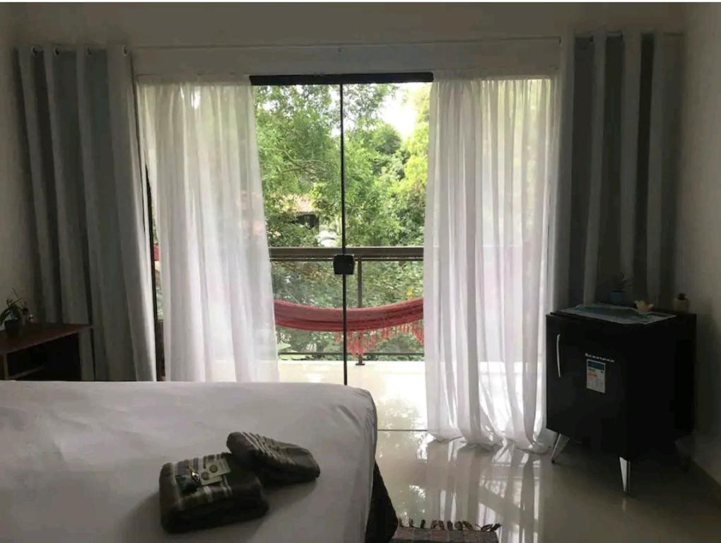 阿布拉奥Ohana suíte Abraão - Ilha Grande的一间卧室设有一张床和一个大窗户