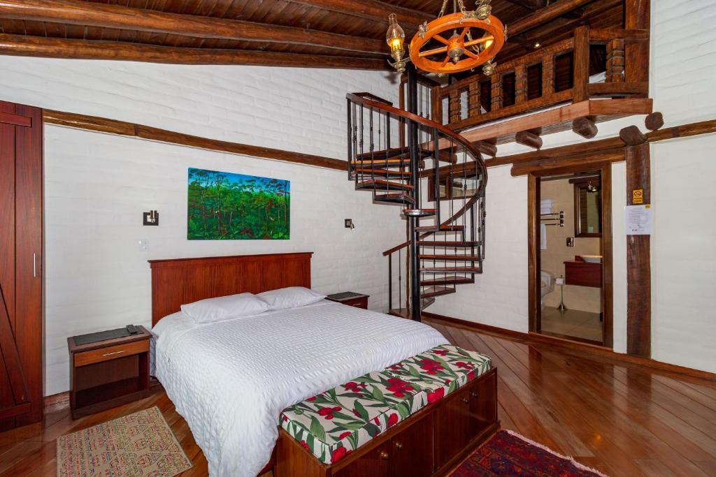 巴尼奥斯Hostal ILÉ的一间卧室设有一张床和一个螺旋楼梯