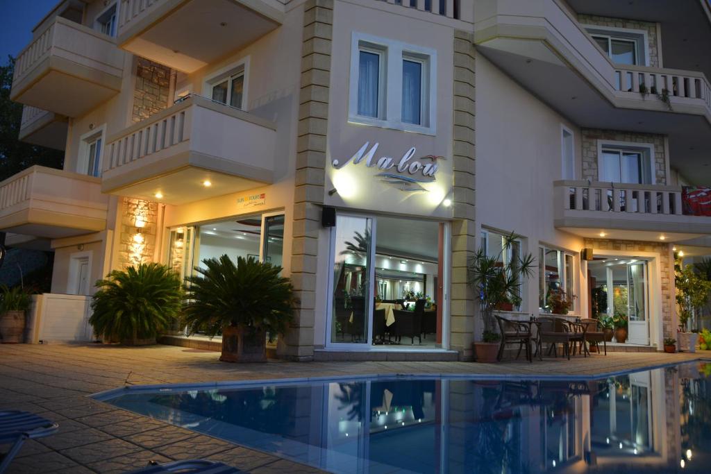 加藤-达拉特索马卢公寓式酒店的一座别墅,在一座建筑前设有一个游泳池