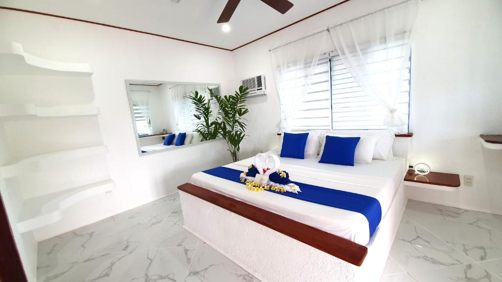 莫阿尔博阿Pawikan Boutique Hotel的一间卧室配有一张带蓝白色枕头的大床
