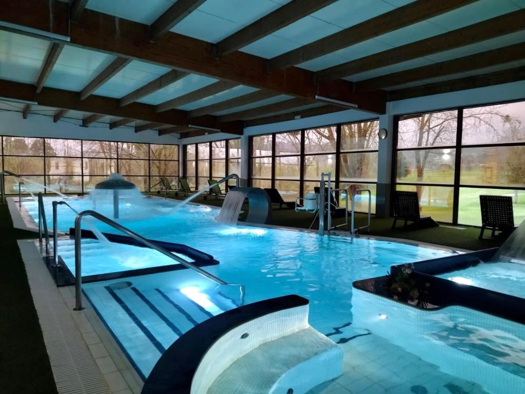 德瓦拉罗丽亚宫OCA酒店及Spa的一座大型游泳池,位于一座带窗户的建筑内