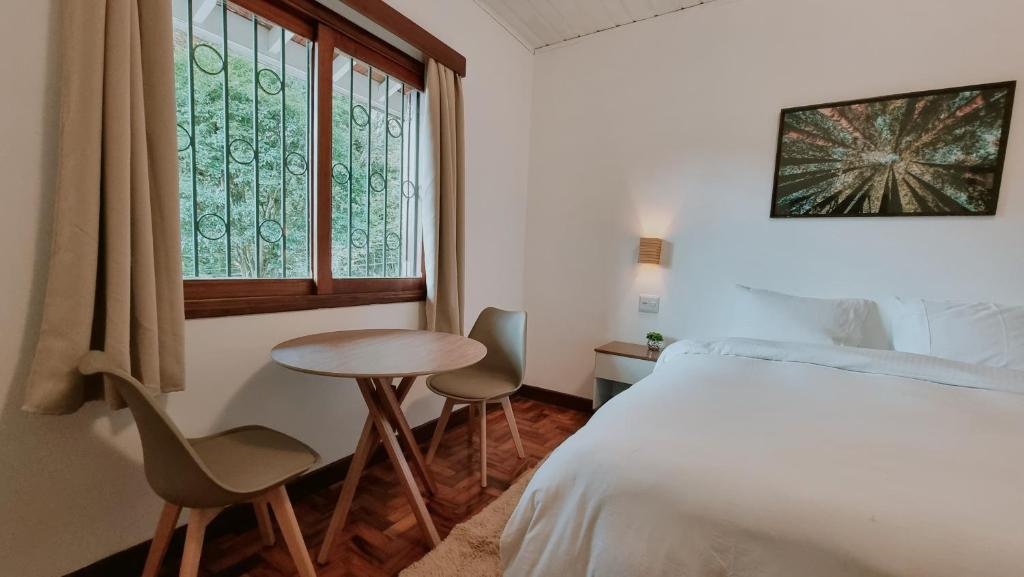 坎波斯杜若尔当Casa Wald的一间卧室配有一张床、一张桌子和一个窗户。