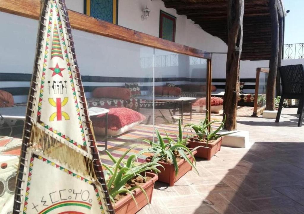 索维拉Appart, Hotel & Café Agadir的冲浪板,站在植物旁的天井上