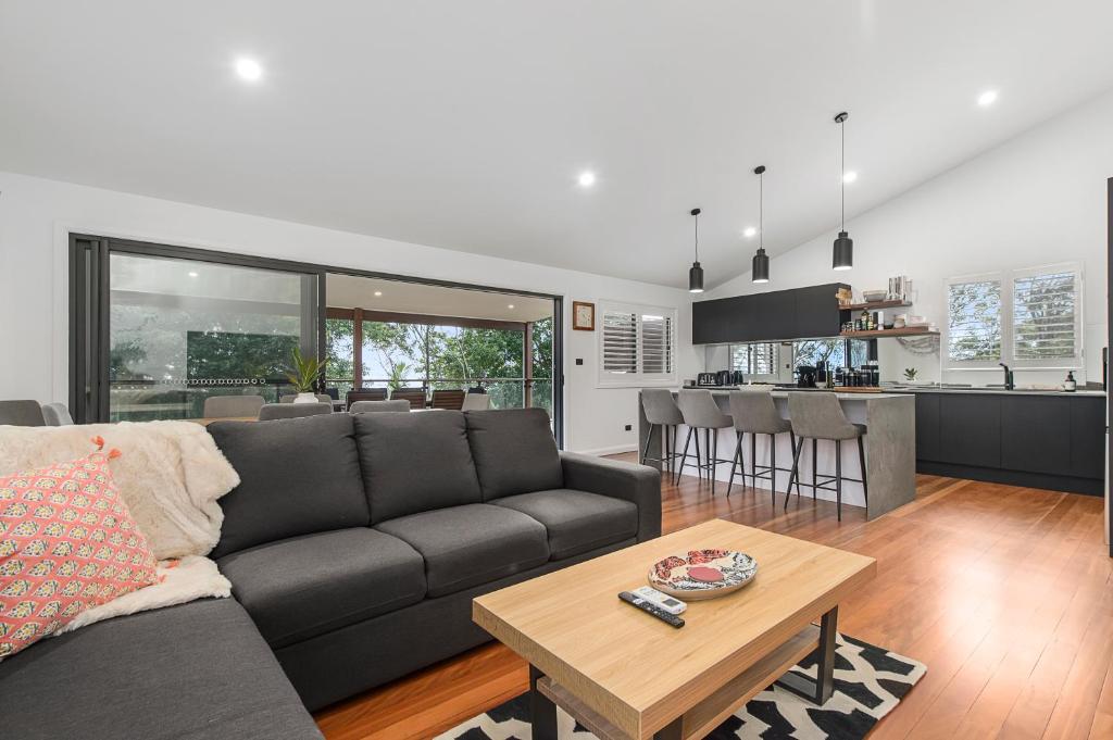 麦夸里港24 Hibiscus Crescent Port Macquarie的客厅以及带沙发和桌子的厨房。
