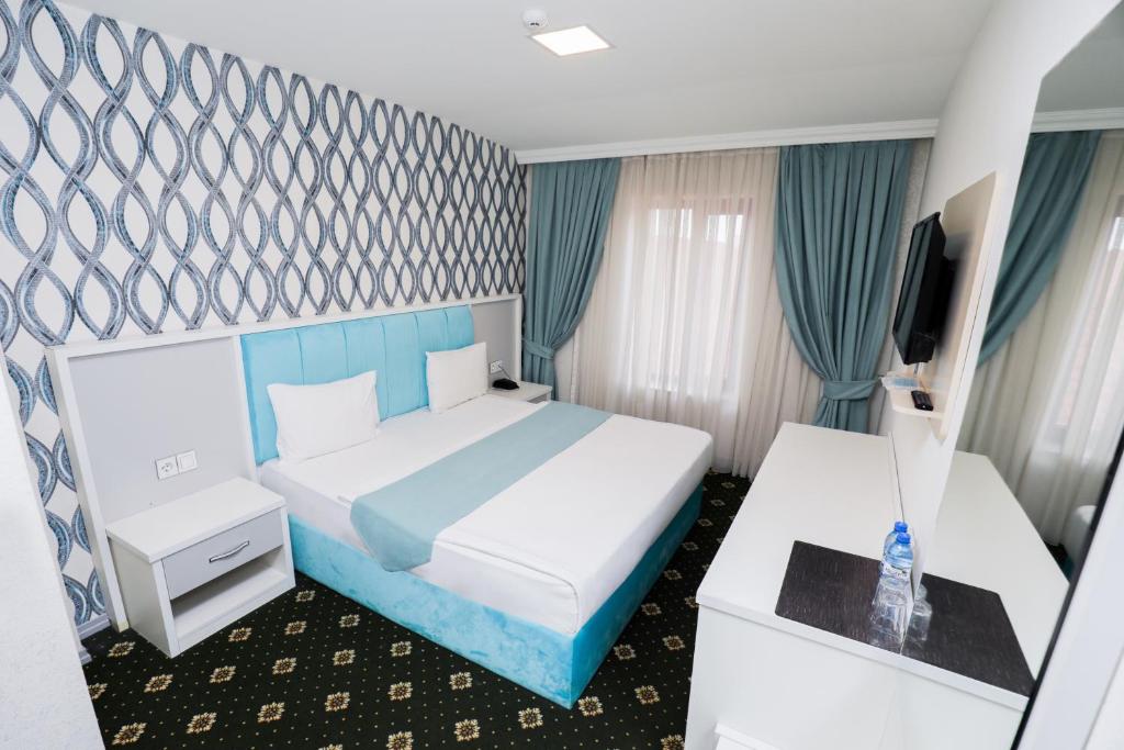 巴库Altus Hotel的一间酒店客房,配有一张床和一台电视