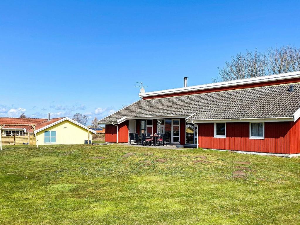 诺德堡12 person holiday home in Nordborg的前面有草坪的红色房子