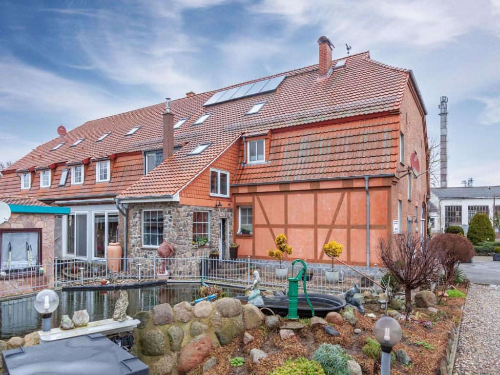 克吕茨Budget Apartment in Grundshagen with garden seating的前面有池塘的房子