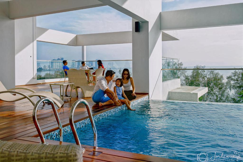 乔治市Sunrise Gurney Premium Executive City/Seafront suite - Penang的一群人坐在游泳池周围