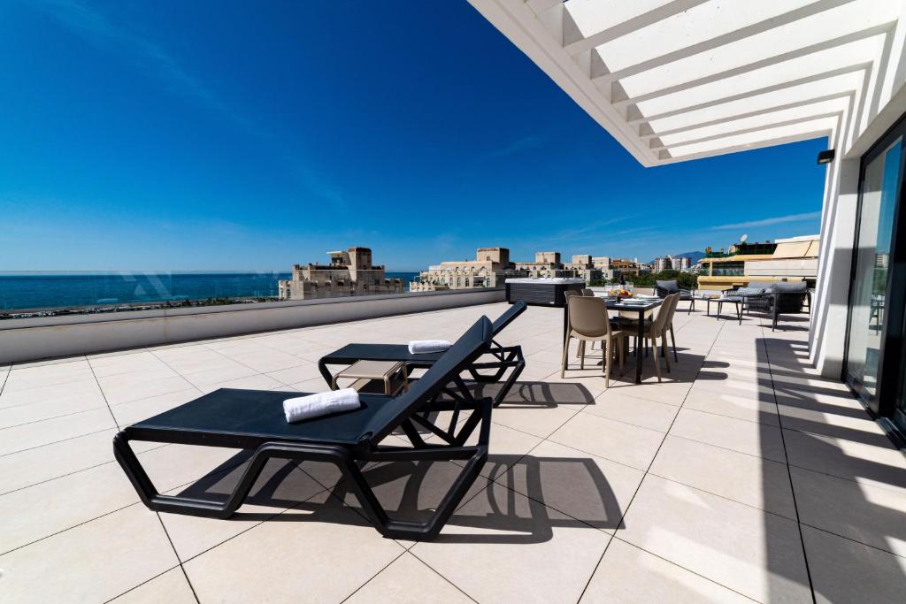 马贝拉Aqua Apartments Bellamar, Marbella的屋顶上带桌椅的天井