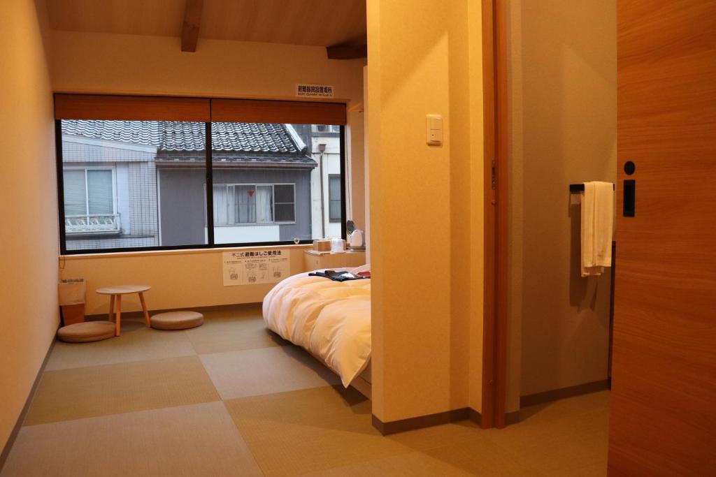 丰冈市城崎温泉 小宿 紬 tsumugi的一间卧室设有一张床和一个大窗户