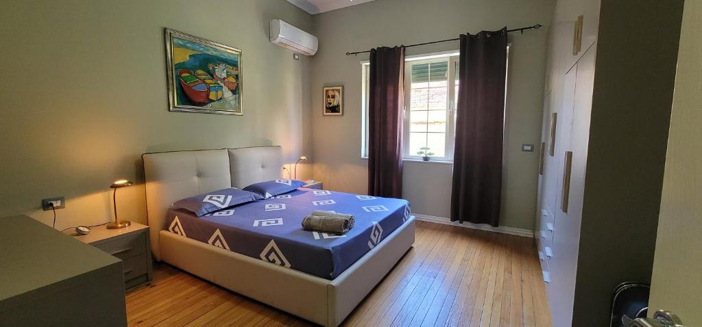 地拉那Bellesuite Tirana的一间卧室配有一张带蓝色棉被的床和窗户。