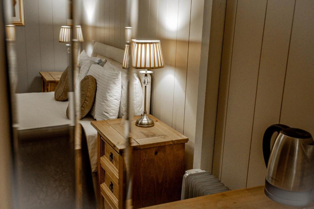 伍勒No1 Hotel的一间卧室配有一张床和一张带台灯的桌子