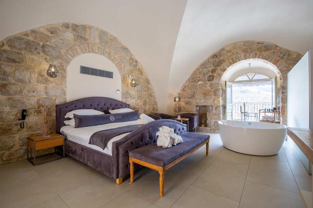 耶路撒冷Lifta Boutique Hotel & Spa的卧室配有床和浴缸