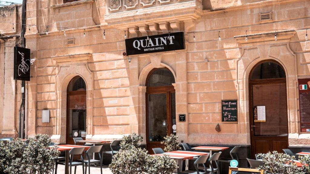 萨奈特Quaint Boutique Hotel Sannat的大楼前设有桌椅的餐厅