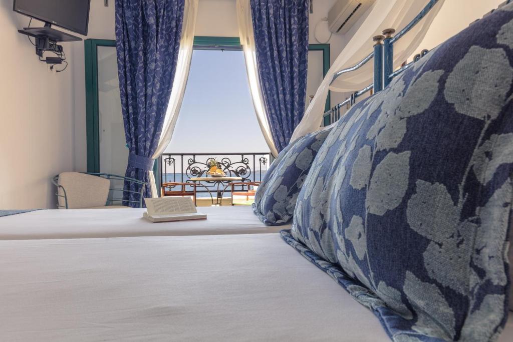 斯卡拉狄俄尼索斯酒店的一间卧室配有一张带笔记本电脑的床