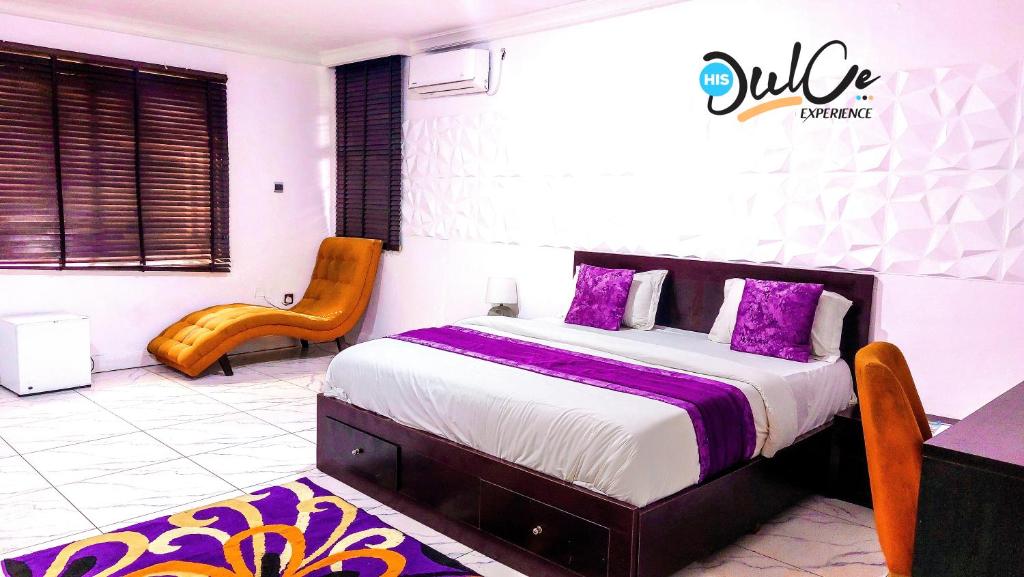拉各斯HIS Dulce Apartments的一间卧室配有一张带紫色枕头的大床