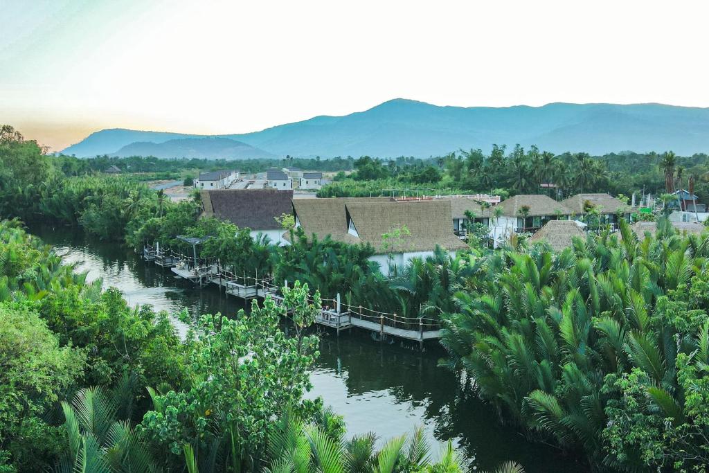 贡布RiverTree Villa & Resort的一条有一堆树木和建筑物的河流
