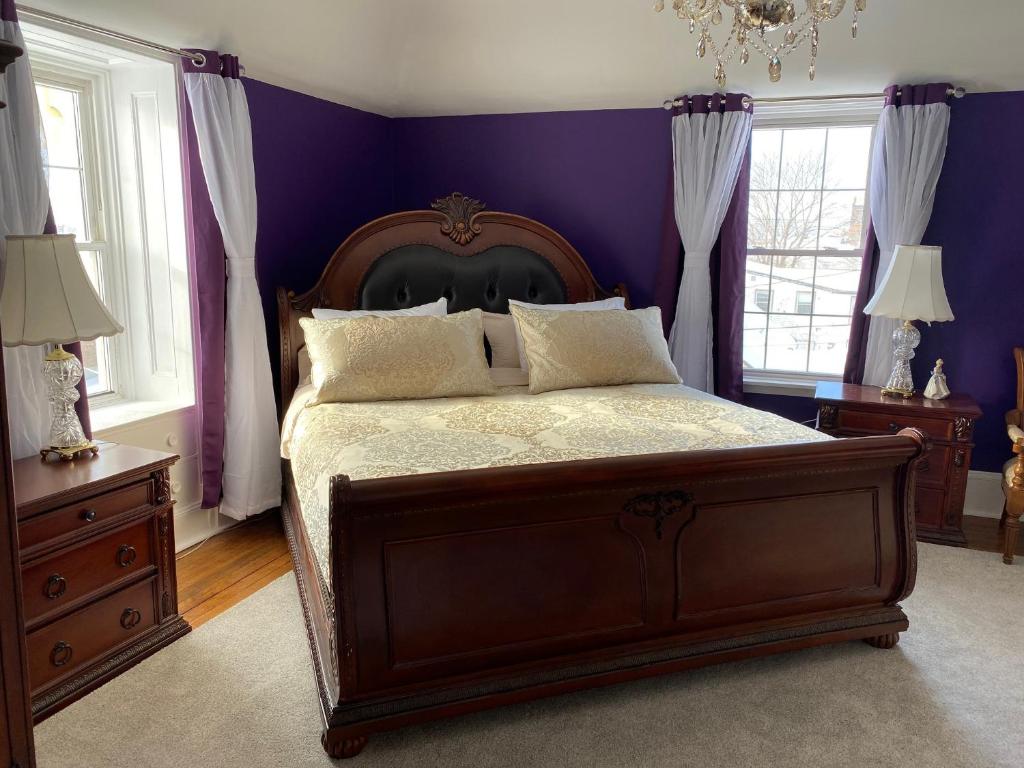 皮克图Seabank House Bed and Breakfast The Royal的一间卧室配有一张紫色墙壁和窗户的床