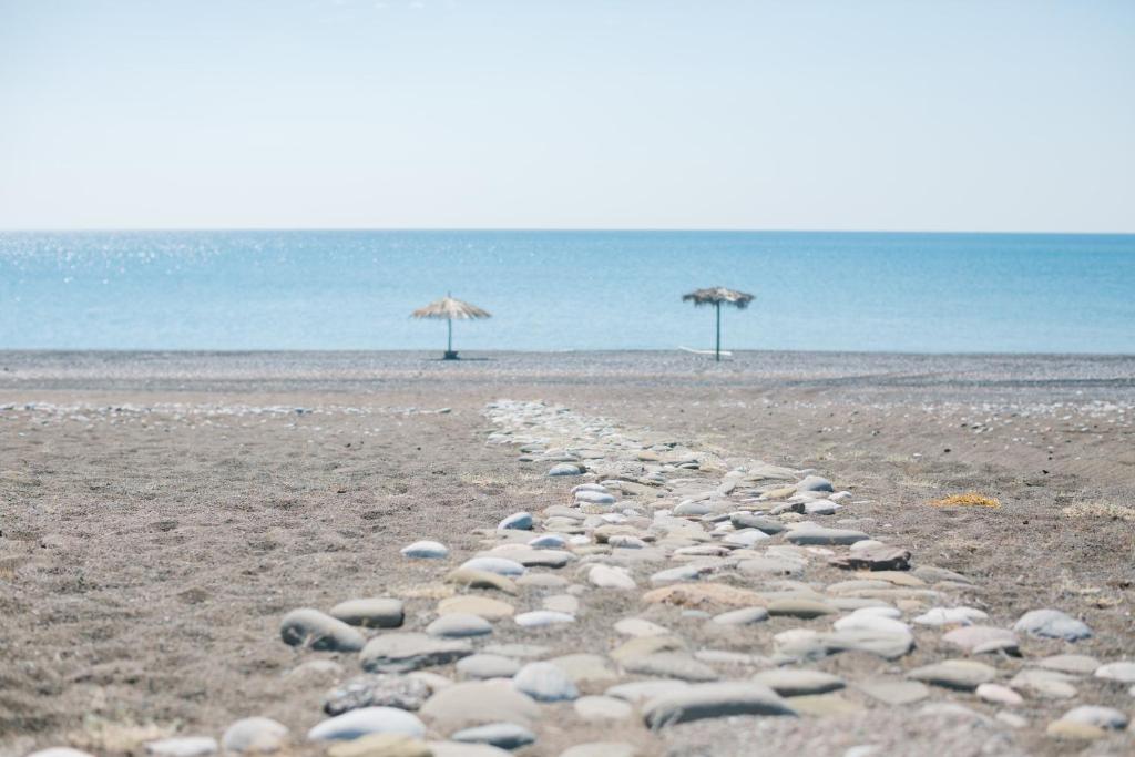 拉卡尼亚Ktima Tzaneti - Coastal Farmhouse的海滩上的一群岩石,上面有遮阳伞