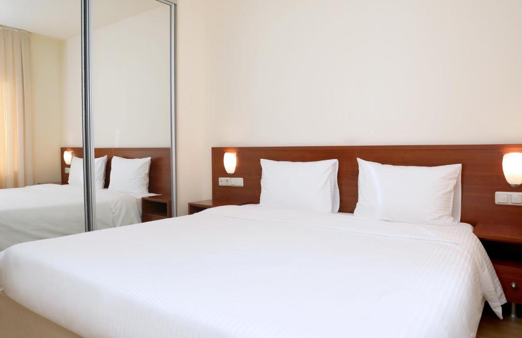 阿格沃兰阿弗兰公园度假酒店的一间卧室设有两张床和大镜子