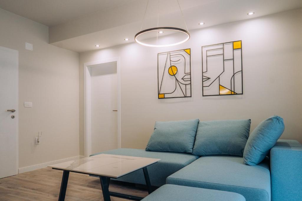 奥赫里德Bellissimo Apartments的客厅配有蓝色的沙发和桌子