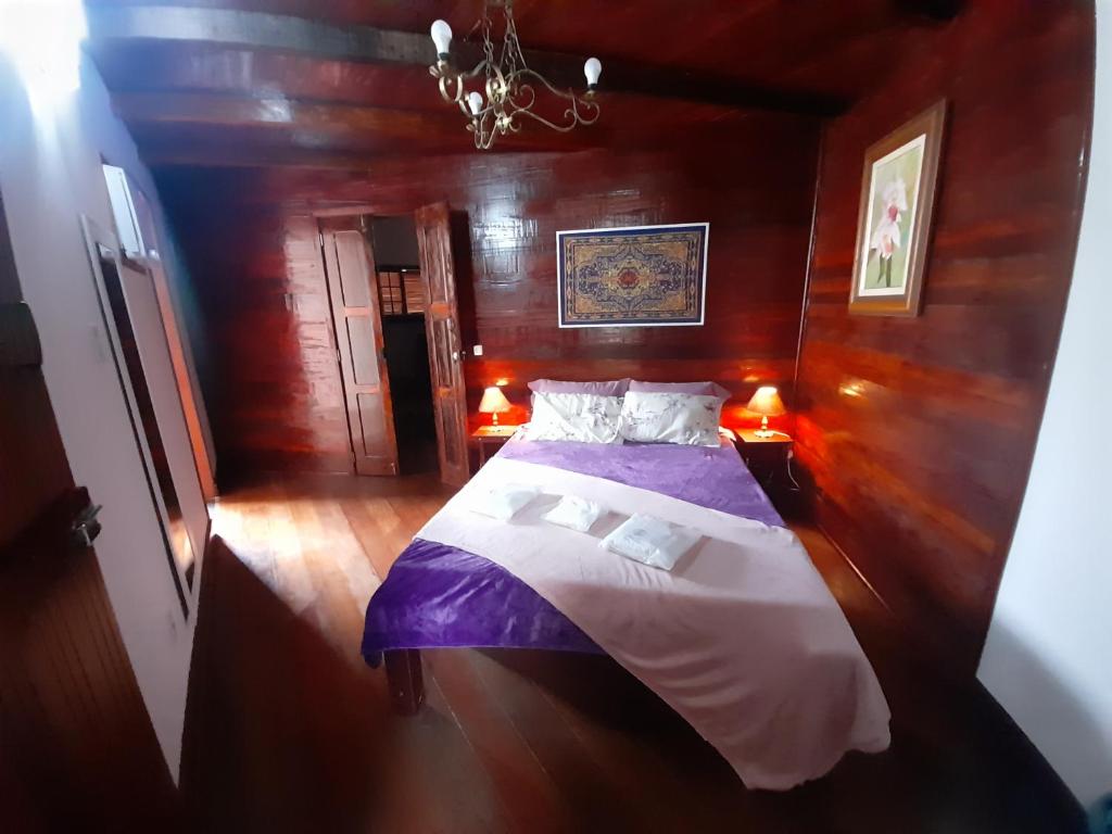 卡波布里奥POUSADA BEIRUTE的木制客房内的一间卧室,配有一张床