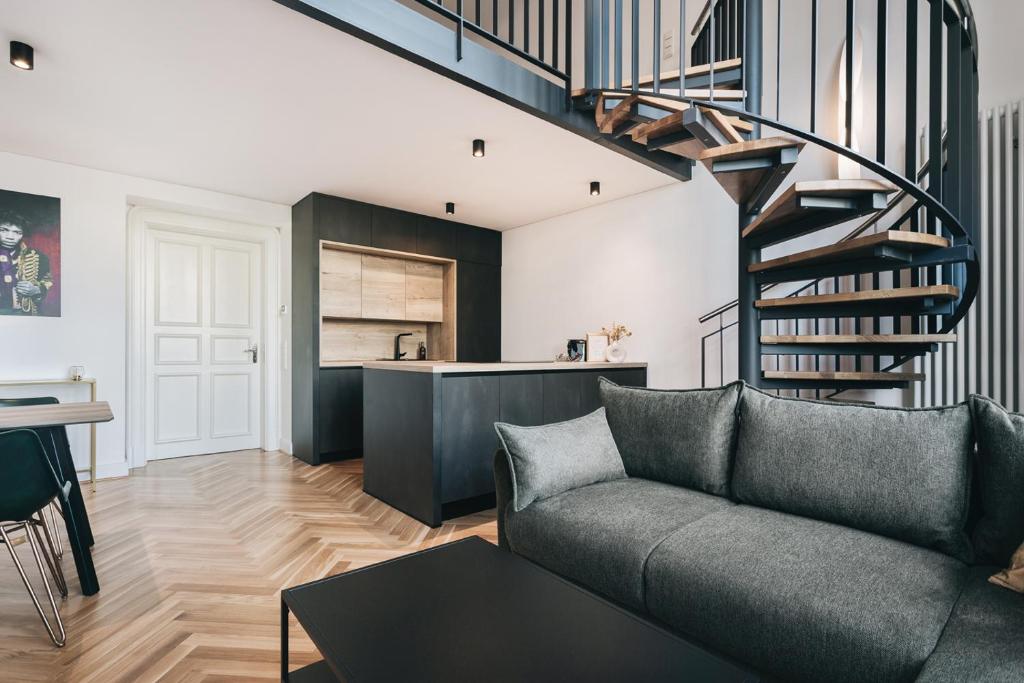 德累斯顿Palais Apartment direkt im Zentrum, FEWO-Residenz-Dresden的带沙发和螺旋楼梯的客厅