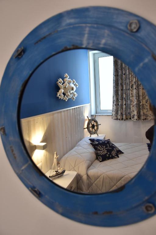 贾迪尼-纳克索斯B&B Marina Blu的一间卧室配有一张床和镜子