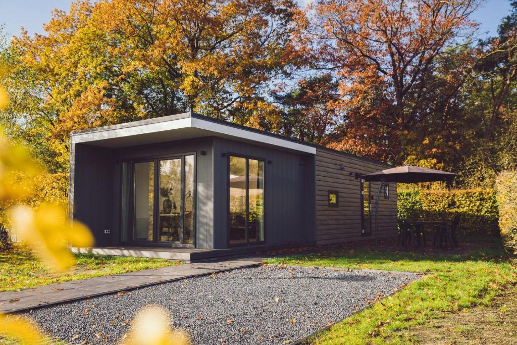 莱森Tiny Cabin with Hottub I 4 p的一座带花园的黑色小房子