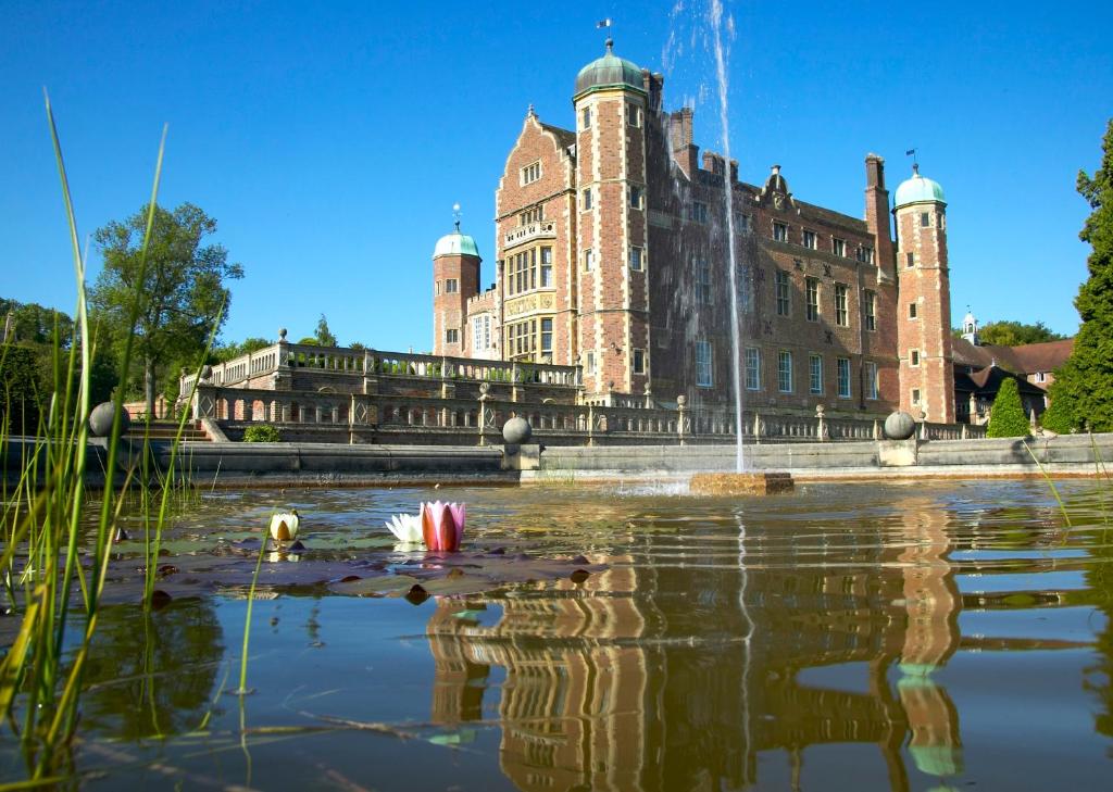 剑桥马丁利礼堂旅舍的一座大建筑,前面有一个池塘