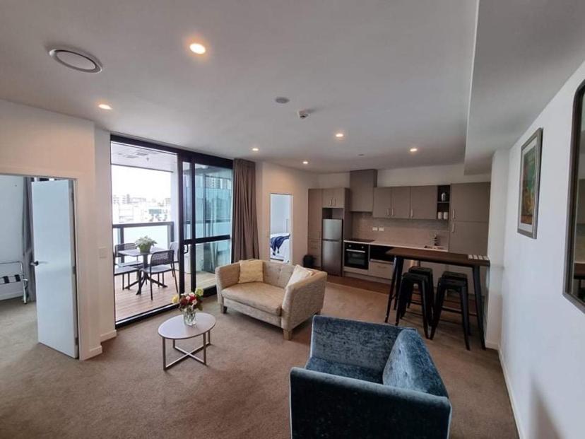 奥克兰Modern, Central City, Penthouse Floor Apartment.的带沙发和桌子的客厅以及厨房。