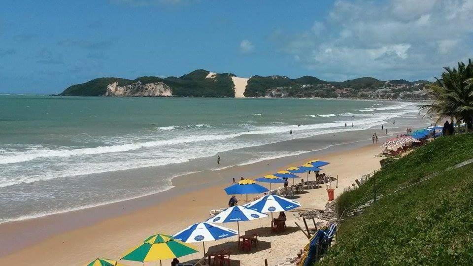 纳塔尔Araça Flat Natal Prime - Beira Mar的海滩上设有遮阳伞和椅子,还有大海