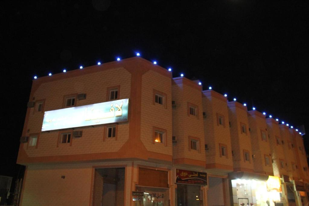 塞卡凯Lavina Hotel Apartments的一座晚上有灯的建筑