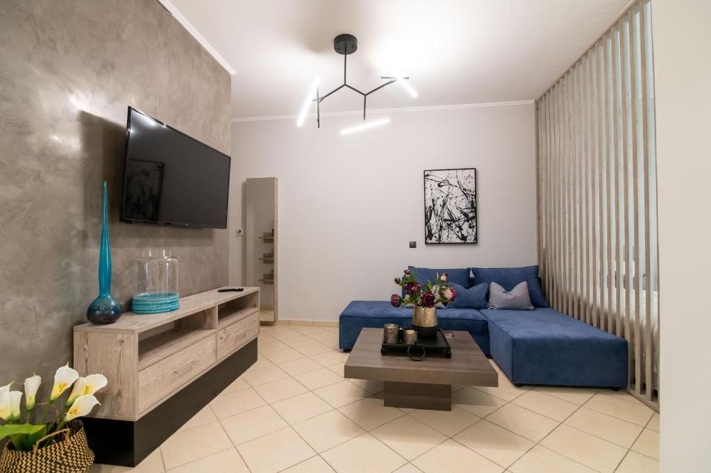 普雷韦扎Elite and Style的客厅配有蓝色的沙发和电视