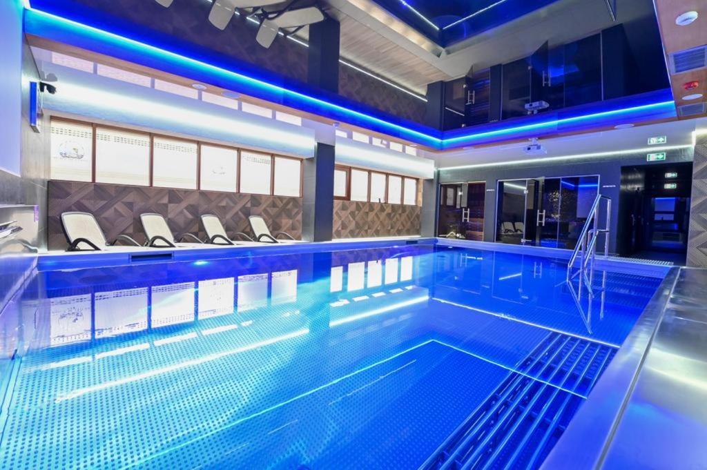 格鲁德柴兹Hotel Rudnik的大楼内带蓝色灯光的大型游泳池
