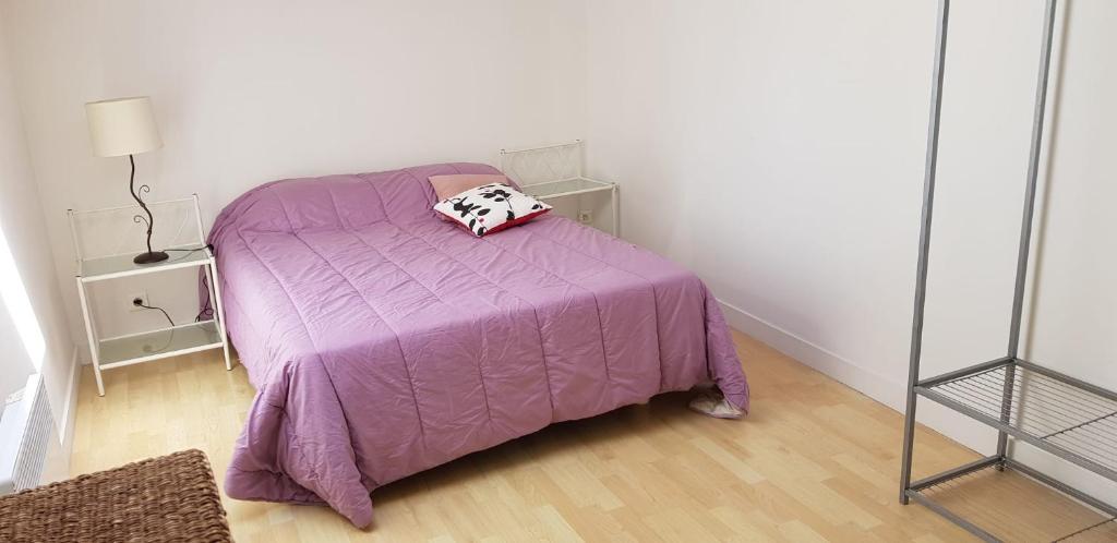 尚尼耶Maison au coeur d'un village près d'Angoulême的一间卧室配有一张紫色床和枕头