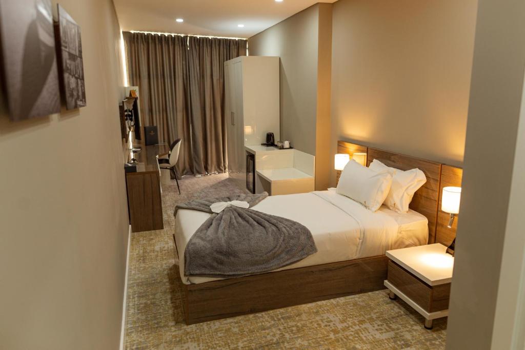 马普托Polana Plaza Hotel的配有一张床和一张书桌的酒店客房