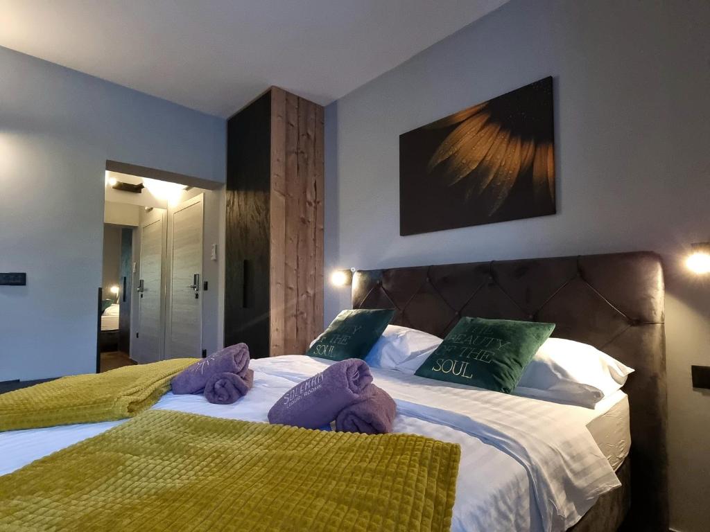 扎达尔Solemar Luxury Rooms的一间卧室配有两张带紫色和绿色枕头的床