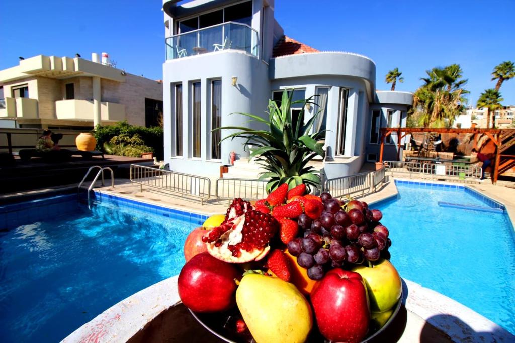 埃拉特克斯托俱乐部旅馆的游泳池前的桌子上放着一碗水果